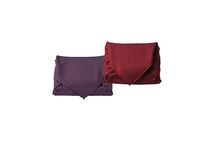 えんじ色と紫色の風呂敷で包んだ立方体が並んでいる。風呂敷は平包みという結び目のない手法で包んである