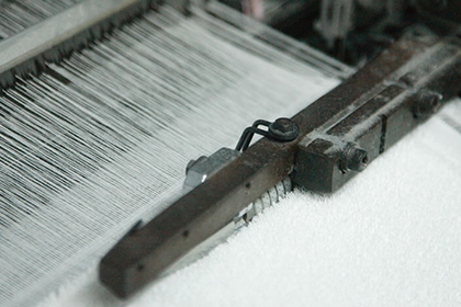 織り機によってタオルが織られていく様子の画像