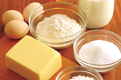 マネケンワッフルを作る材料である卵、小麦粉、牛乳、砂糖、バターが並んだ画像